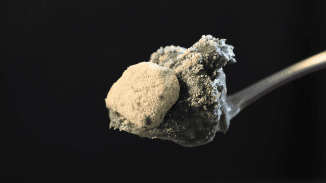Spoonful of green rice cake dessert sprinkled with powder