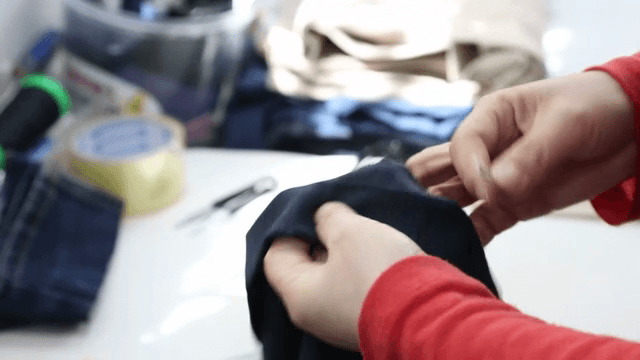Hands working on fabric in a sewing room