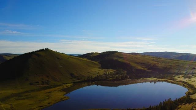 Serene lake surrounded by green hills