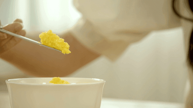 Woman scooping up yellow rice with chopsticks