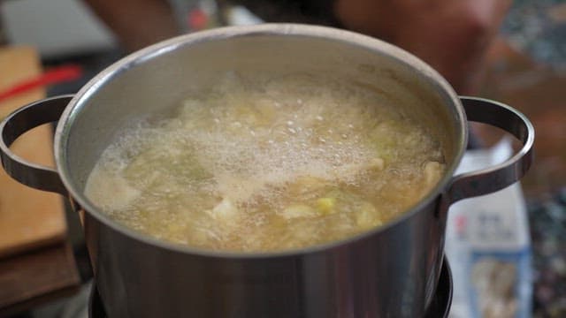 냄비에서 펄펄 끓고 있는 국물에 수제비 반죽을 떼어 넣는 모습