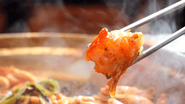 Fried cod dipped in cod soup boiling in pot