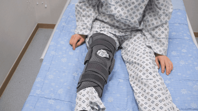 Patient wearing knee brace in bed