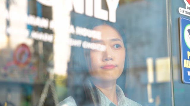 유리문 너머로 남성을 반기는 여성