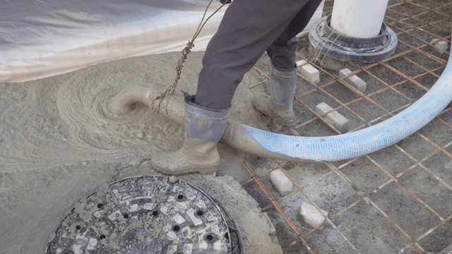 Workers pouring and leveling concrete