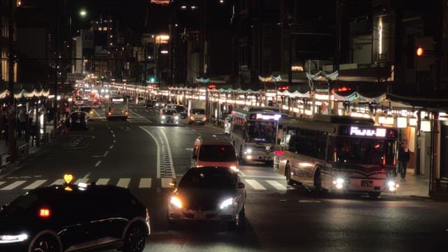 차들과 버스들이 있는 번화한 야간 거리