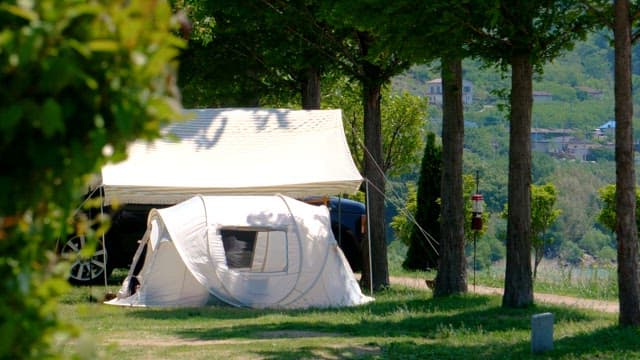 Camping tent set up in a grassy area on a sunny day