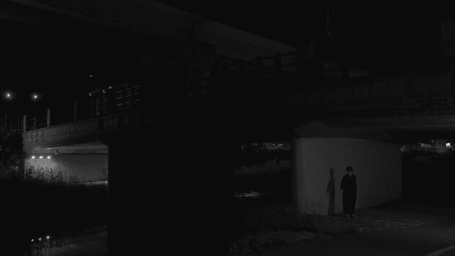 밤에 다리 아래 서 있는 사람