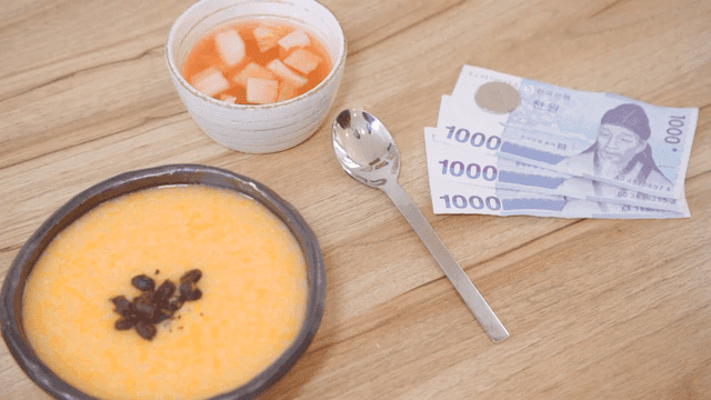 그릇에 담긴 한국식 호박죽과 한국 돈