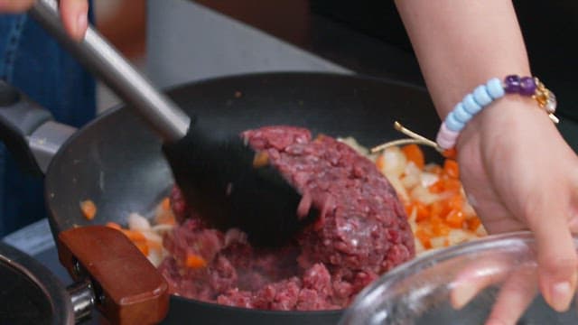 Cooking ground beef with vegetables in a pan