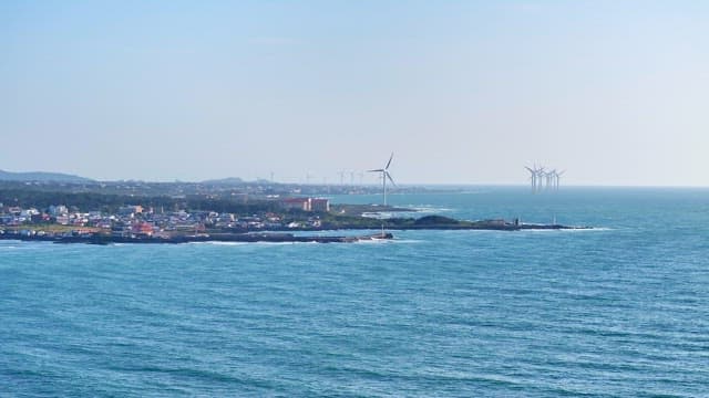 Coastal town with wind turbines and ocean