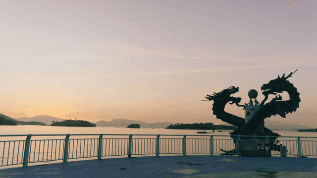Dragon statue overlooking the sea at sunset