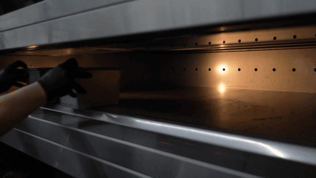 Baker putting baking tray in oven