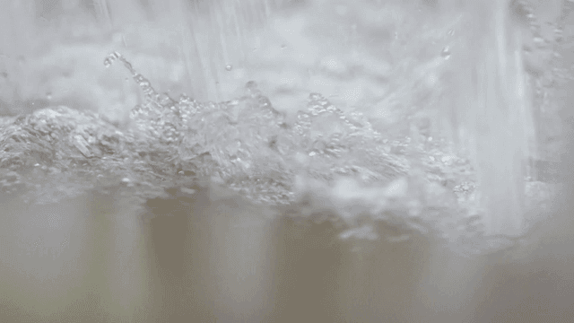 Stream of water splashing with water droplets