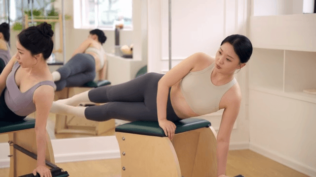 Two women practicing pilates indoors