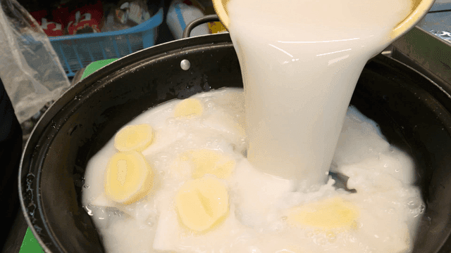 Rice water poured into pot containing vegetables