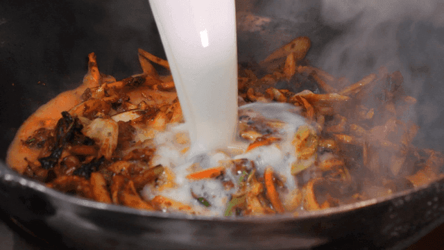 Broth poured over spicy stir-fried vegetables