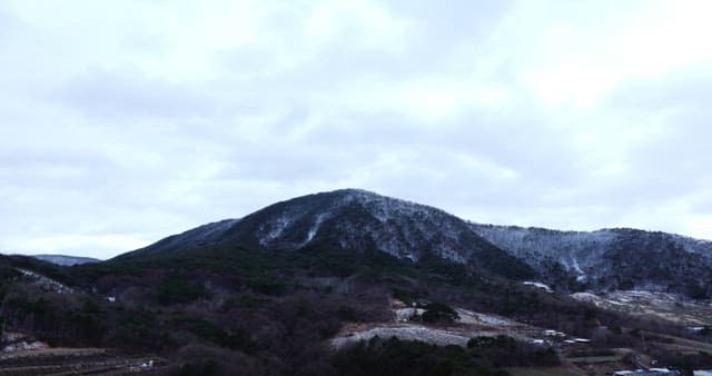 Snow-covered mountains under cloudy skies