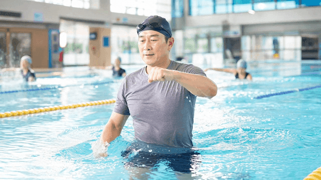 Elderly man doing aqua aerobics in swimming pool