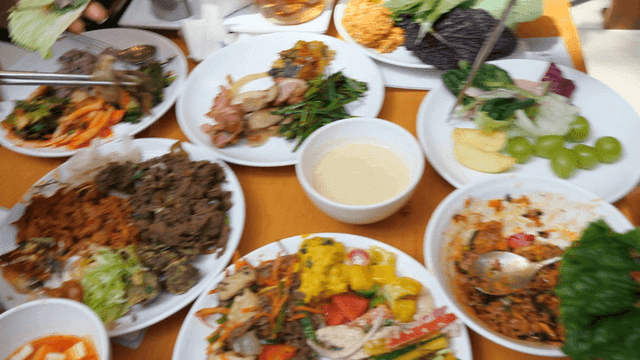 People eating various Korean dishes on table