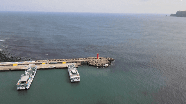 Pier with ferry and red lighthouse