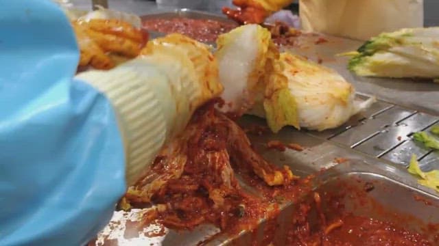 배추에 고추 양념을 넣어 김치를 만드는 모습