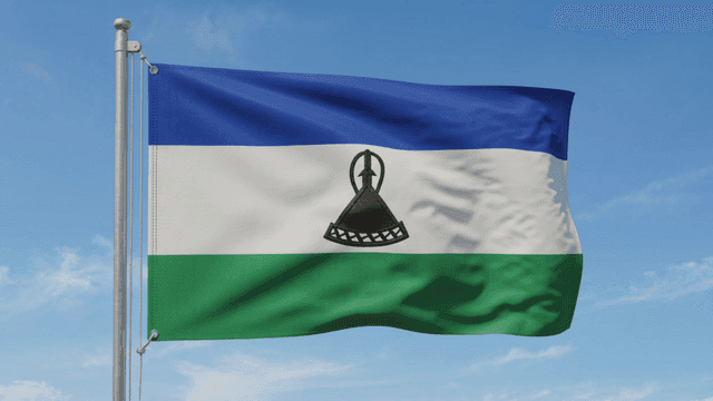Flag of Kingdom of Lesotho fluttering under clear sky