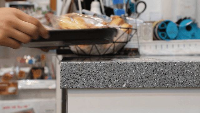 Bakery counter with pastries and hands