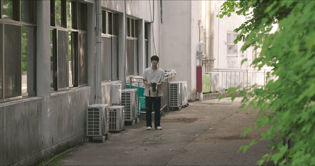골목에서 카메라를 들고 있는 사람