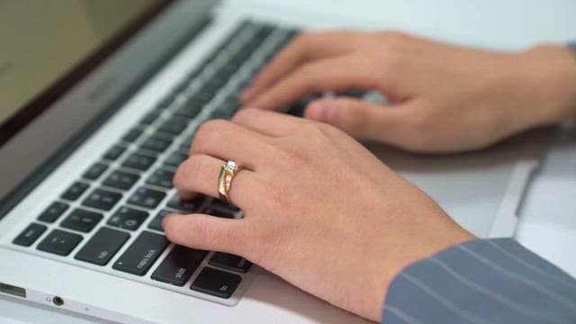 실내에서 노트북 키보드를 타이핑하는 손