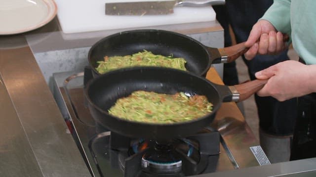 두 개의 프라이팬에서 요리하는 애호박전