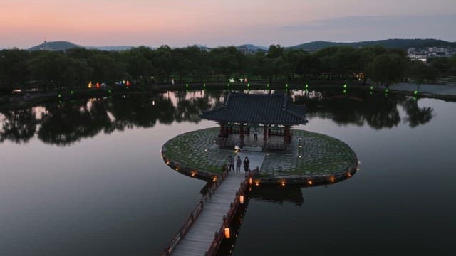Traditional pavilion on a serene pond at sunset