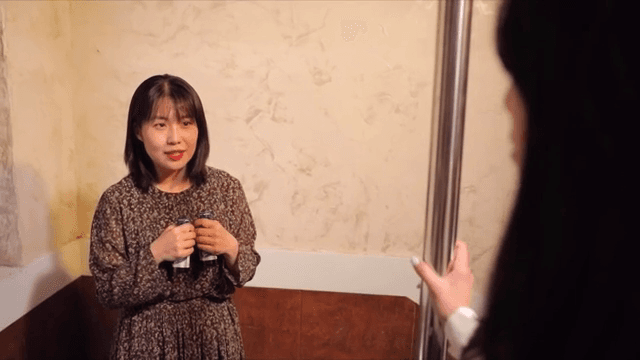 누군가와 대화하다가 음료를 건네는 여성