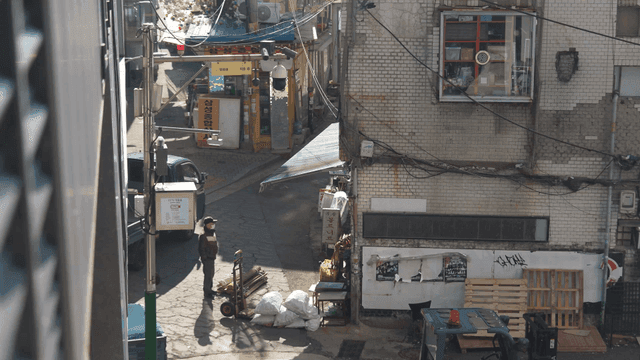 Old man and cart loaded with waste paper standing in quiet alley