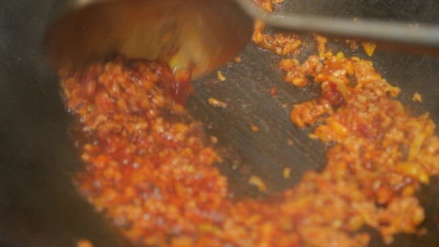 Stir-frying minced meat and onions in a hot wok