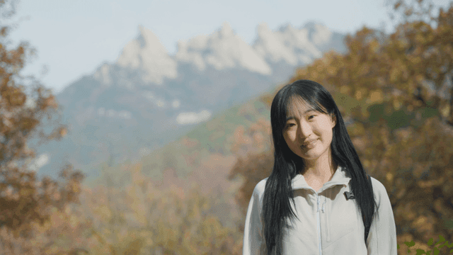 Smiling woman with view of autumn mountain summit