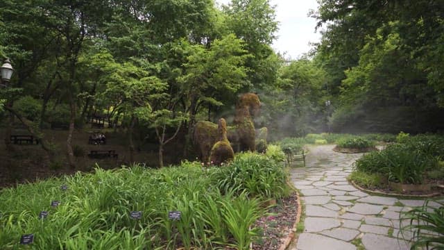 동물 조형물이 있는 조용한 정원과 관광객들