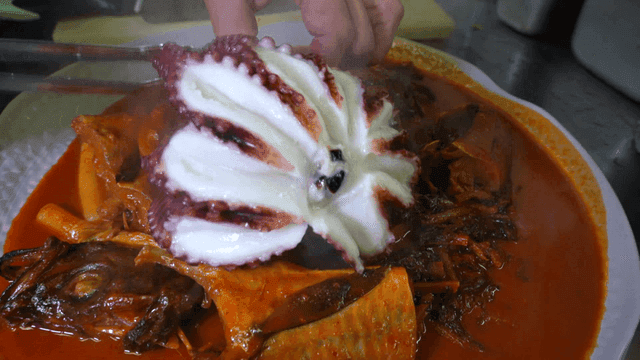 Boiled octopus served on fish braised in spicy sauce