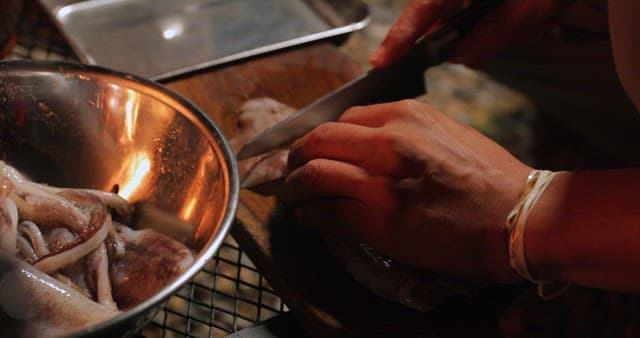 Preparing seafood in a outdoor kitchen at night