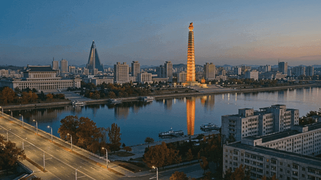 North Korean city skyline with river visible in evening