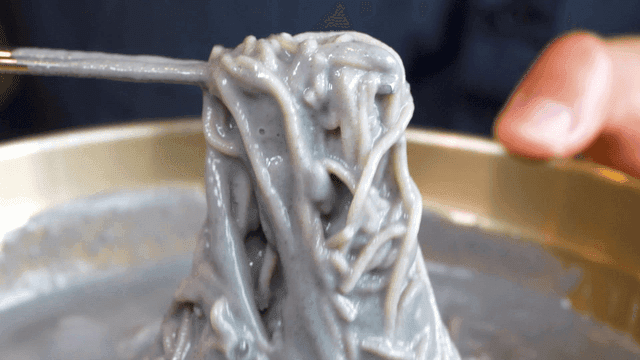 비벼진 서리태 메밀막국수를 드는 젓가락