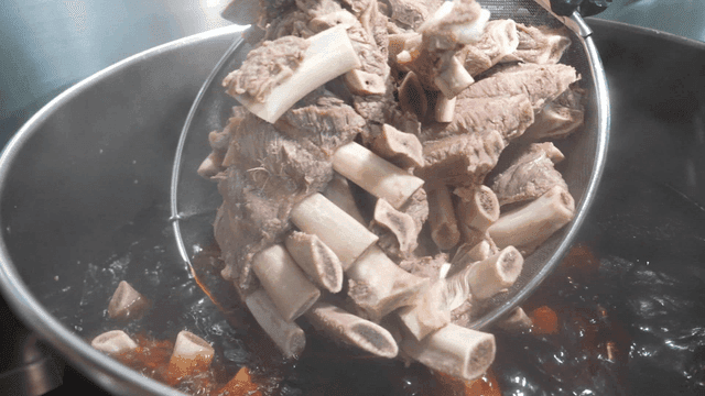 Beef ribs being boiled in large pot