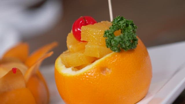 접시에 장식용 체리와 채소를 얹은 신선한 과일 디저트