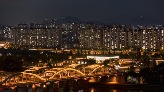 Night cityscape with illuminated skyscrapers and busy bridge in the foreground