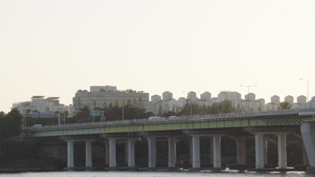 Calm Waterfront Cityscape and Bridge with Cars