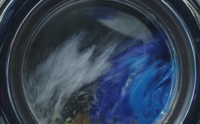 빨랫감이 든 채 작동되는 드럼 세탁기