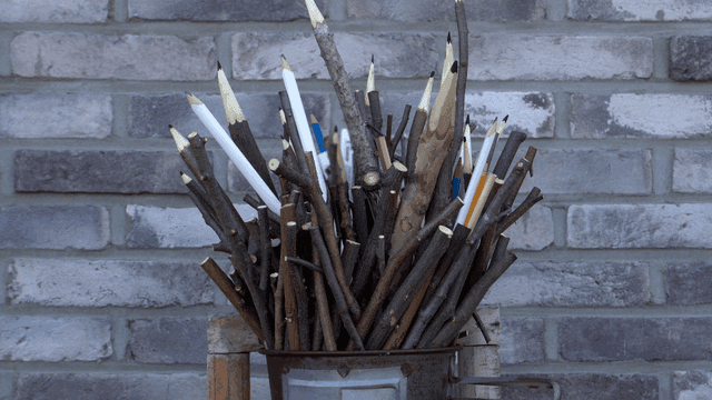 벽돌 배경의 나뭇가지 연필 조각품