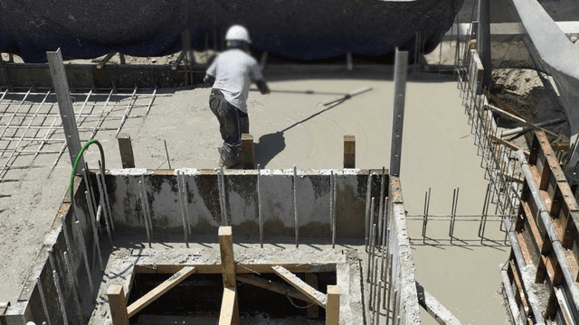 Worker smoothing concrete at a construction site