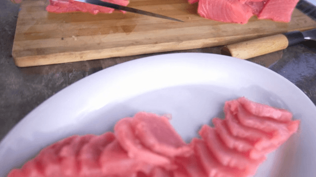 나무 도마 위에 신선한 참치 썰기