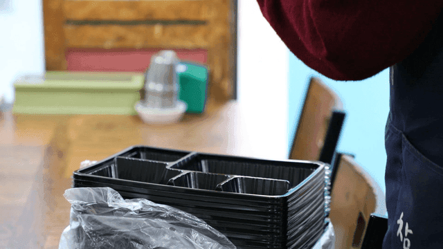 실내에서 플라스틱 트레이를 정리하는 손